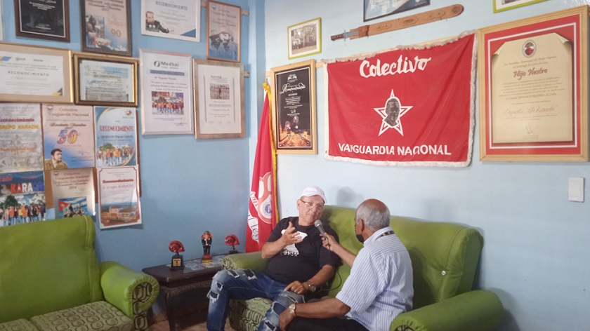 A la izquierda, Fernando Álvarez Caula, o mejor: Fernando Karachi, el director de la orquesta, habla sobre el grupo. En las paredes una pequeña muestra del porqué ellos son “La orquesta del pueblo”